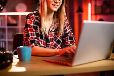 Ev ofisinde otururken klavyeye yazı yazan Kafkasyalı genç bayanı yakından çek. Evde kablosuz bilgisayar kullanan serbest çalışan bir erkek. Uzaktan çalışma teknolojisi.