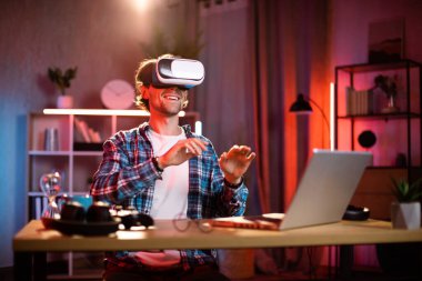 Evde uzaktan çalışırken kablosuz sanal gerçeklik gözlüğü kullanan beyaz bir adam. İnsanların kavramı, teknoloji ve artırılmış gerçeklik.