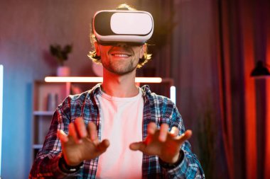 Evde uzaktan çalışırken kablosuz sanal gerçeklik gözlüğü kullanan beyaz bir adam. İnsanların kavramı, teknoloji ve artırılmış gerçeklik.