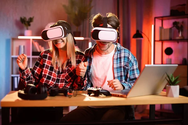 Genç, güzel bir kadın ve yakışıklı bir adam sanal gerçeklik kulaklığı takmış el ele tutuşuyorlar. Gençler evlerinde yeni moda teknolojiyle eğleniyorlar. Oyun konsepti.