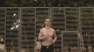 Açık hava basketbol sahasında koşan, aktif kıyafetli, sportif beyaz bir adam. Genç ve çekici bir adam dışarıda çalışmaktan hoşlanıyor. İnsan kavramı, spor ve güç.