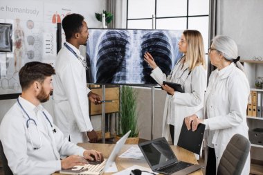Uluslararası doktorlar bir araya gelerek akciğer röntgenini tartıştılar ve ilerici tanı merkezini oluşturdular. Çok ırklı nitelikli personel tedavi yöntemlerini aramak için iş toplantısı yapıyor.