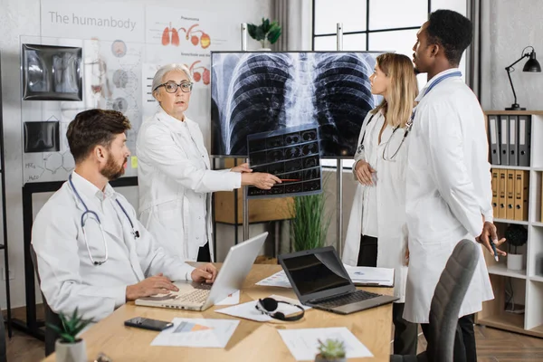 Kaukasische Senior Therapeut Glimlachend Kijkend Naar Camera Terwijl Hij Wijst — Stockfoto