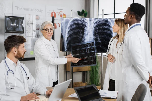 Kaukasische Senior Therapeut Glimlachend Kijkend Naar Camera Terwijl Hij Wijst — Stockfoto