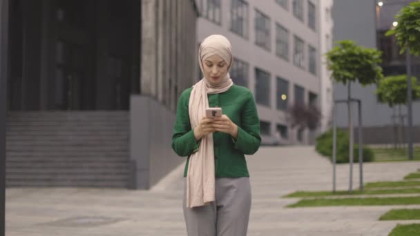 Аравійська Жінка Хіджабі Стоїть Біля Сучасного Ділового Центру Смартфоном Руках — стокове відео