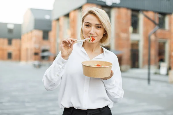 仕事中に休憩しながら健康的なサラダを食べる笑顔のビジネス女性の肖像画 親切なPositiv女性食べる彼女のサラダながら 街の通りにある — ストック写真