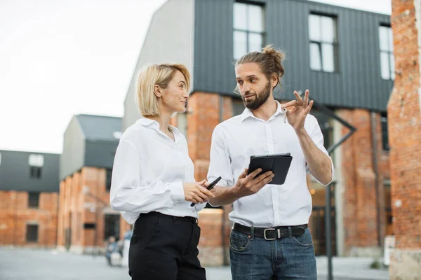 Happy smiling business woman taking key of future new apartment. Professional real estate agent wearing white shirt holding in hand and giving keys to young buyer. Mortgage, Property For Sale Concept