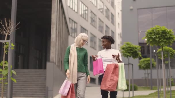 Két Csinos Multiracionális Fiatal Legjobb Barátnő Sétálnak Gyönyörű Modern Városban — Stock videók