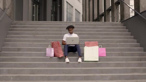 Mutlu Bir Afrikalı Kız Modern Bir Binanın Merdivenlerinde Oturmuş Alışveriş — Stok video