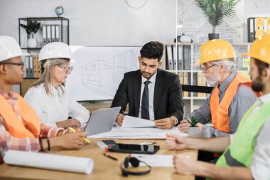 İnşaat tasarımcılarından oluşan bir takım, ofiste otururken yeni bir proje planlayan mimarlar. Birlikte çalışan bir grup insan. İnşaat endüstrisi.