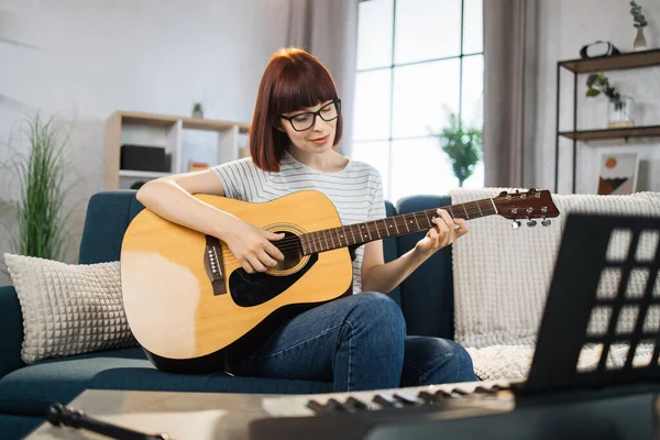 A music teacher conducts a lesson on playing a musical instrument over the Internet. Guitar lessons online and online music training during quarantine for the coronavirus pandemic.