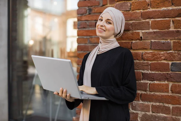 Портрет Усміхненої Мусульманки Розслабляється Допомогою Цифрового Ноутбука Стоїть Біля Стіни — стокове фото