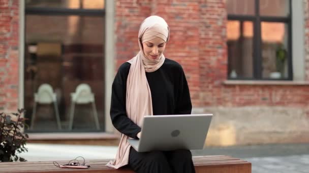 Όμορφη Χαμογελαστή Μουσουλμάνα Επιχειρηματίας Μαντίλα Κάθεται Στον Πάγκο Και Χρησιμοποιεί — Αρχείο Βίντεο