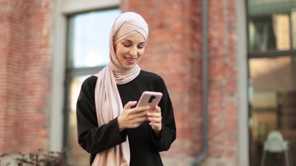 Ganska Leende Muslimsk Affärskvinna Hijab Sitter Bänken Och Använder Smarttelefon — Stockvideo
