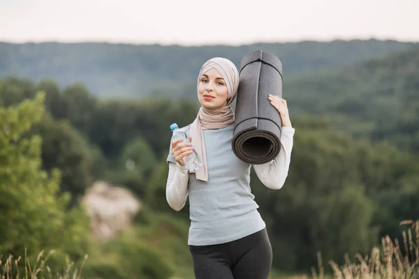 Mujer Hijab Ropa Deportiva Sosteniendo Botella Con Agua Mientras Sonríe — Foto de Stock