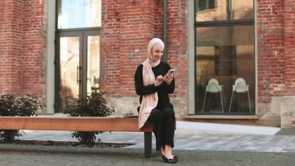 Junge Lächelnde Fröhliche Muslimin Telefoniert Mit Dem Smartphone Der Stadt — Stockvideo