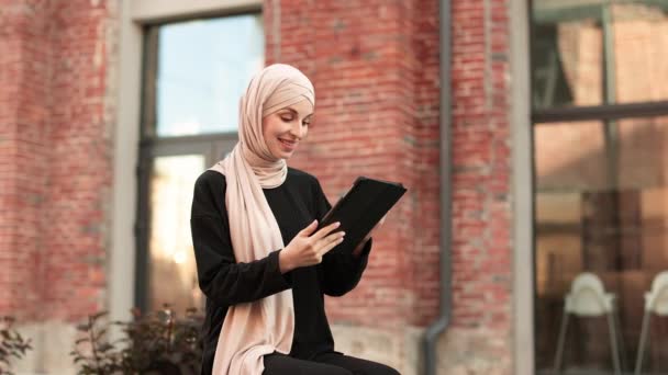 Pretty Smiling Muslim Business Woman Hijab Sitting Bench Using Tablet — Vídeo de Stock