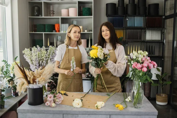 Concentrated Female Colleagues Aprons Working Together Flower Shop Composing Bouquets — стоковое фото