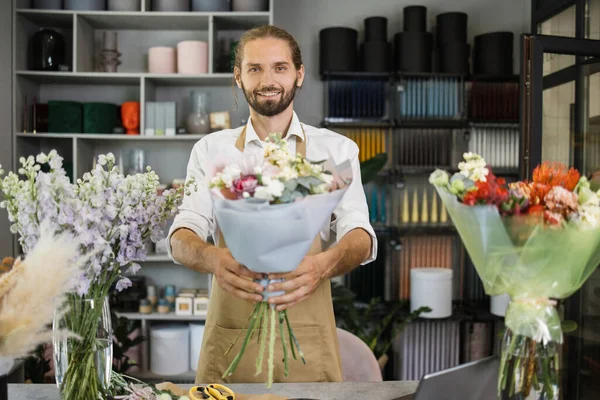 Усміхнений Чоловічий Флорист Уніформі Працює Квітковому Магазині Лічильником Різними Сортами — стокове фото