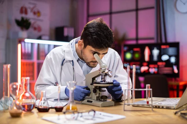 Young Indian Male Researcher Looking Microscope Analyze Science Forensics Microbiology — Zdjęcie stockowe