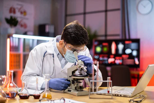 Modern medical research laboratory: portrait of scientist working, using microscope, analyzing samples. Advanced scientific pharmaceutical lab for medicine, biotechnology development.