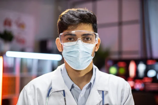 Portrait of professional indian man microbiologist or medical worker using protective mask in the laboratory.