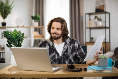 Caucasian man presenting financial report to colleagues through video call on laptop. Male freelancer sitting at workplace and talking with client.
