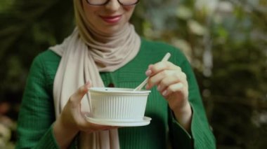 Close up view of hand of woman having a vegetables salad for lunch, healthy eating standing on background of tropics, lifestyle, weekend concept, unrecognizable person.