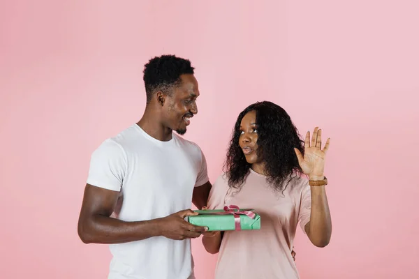 Happy African Man Giving Gifts His Girlfriend Pink Studio Background — Zdjęcie stockowe