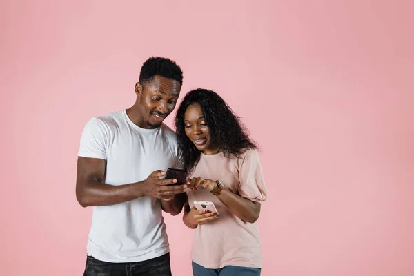 Attractive African Couple Hold Smart Phones Having Fun Internet Girl — Zdjęcie stockowe