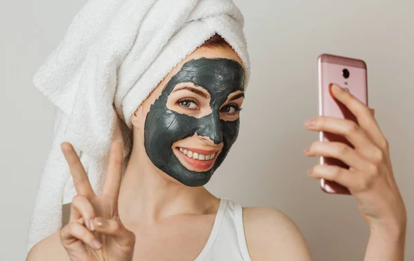 Attractive Young Woman Black Cosmetic Mask Her Face Holding Smart — Stock fotografie