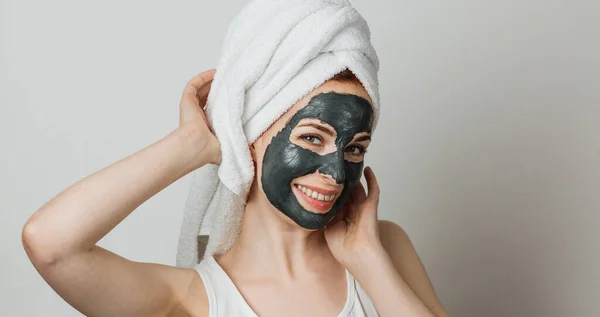 Beautiful Young Woman Black Cosmetic Mask Face Towel Grey Background — Stock fotografie