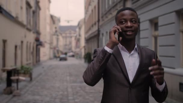 Африканский Мужчина Деловом Костюме Разговаривает Мобильном Телефоне Гуляя Городской Улице — стоковое видео