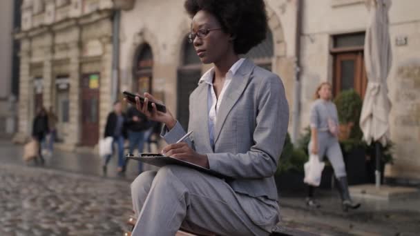 Афро Американская Деловая Леди Сидя Скамейке Запасных Пользуется Современным Смартфоном — стоковое видео