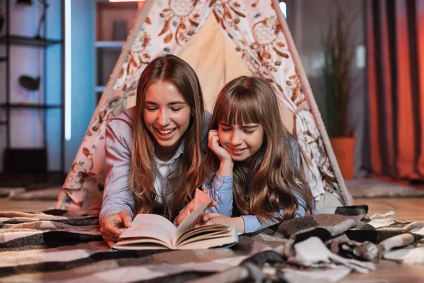 Happy Caring Nanny Older Sister Reading Fairytale Her Younger Sister — Stok fotoğraf