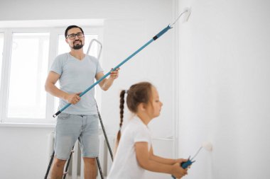 Çekici bir baba ve küçük tatlı bir kızın olduğu genç bir aile odayı tamir ederken eğleniyorlar. Duvarı babasıyla boyanmış küçük bir kız. Babana odaklan..