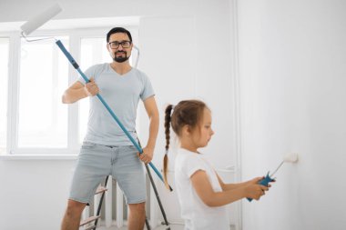 Çekici bir baba ve küçük tatlı bir kızın olduğu genç bir aile odayı tamir ederken eğleniyorlar. Duvarı babasıyla boyanmış küçük bir kız. Babana odaklan..