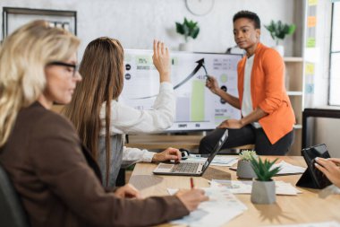 Çok ırklı kadın simsarlar, başarılı bir iş projesi stratejisi geliştirmek için ofiste vakit geçiriyorlar. Masada oturup finansal istatistiklerle bilgisayar ekranına bakan dört kadın..