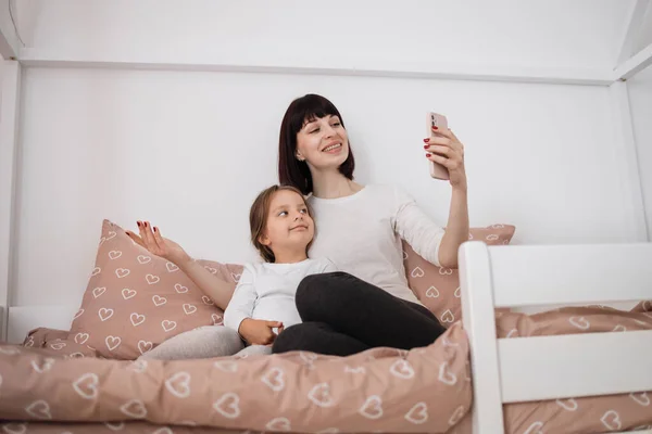 Neşeli Anne Genç Kız Evde Oturup Akıllı Telefon Uygulaması Kullanarak — Stok fotoğraf