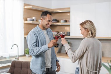 Mutlu çokuluslu çift stüdyo dairelerinin mutfağında sağlıklı vejetaryen yemekleri pişirirken eğleniyor. Karı koca aktif bir hayat sürüyorlar, hayattan zevk alıyorlar, birlikte vakit geçiriyorlar..