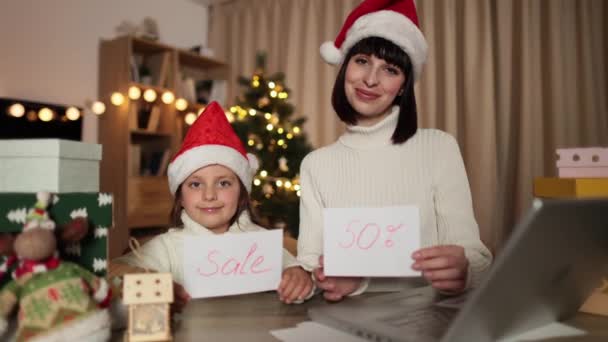 幸せな家族 若い美しい母親と赤い帽子の小さなかわいい子供の娘は 装飾された家で夜に クリスマス イブに販売の碑文と手紙を持っています 休日割引の概念 — ストック動画