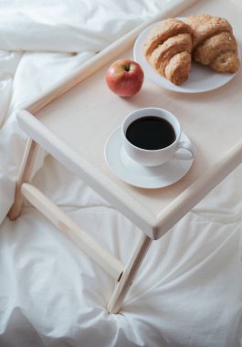 Yatmak için tahta masada kahvaltı. Sağlıklı bir sabah için kahve, kek ve elma.. 