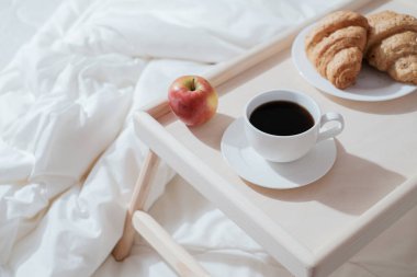 Yatmak için tahta masada kahvaltı. Sağlıklı bir sabah için kahve, kek ve elma.. 