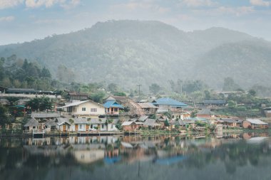 Rak Thai Köyü 'ndeki rıhtım evi, kırsal köy ve Tayland' ın kuzeyindeki su üzerinde dağ yansıması.