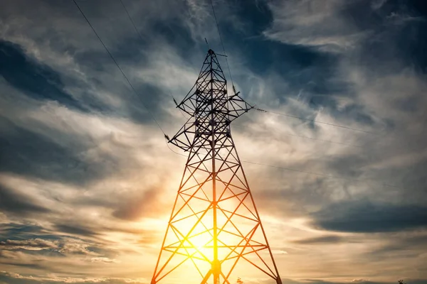 Electric tower on a background of sun and cloudy sky