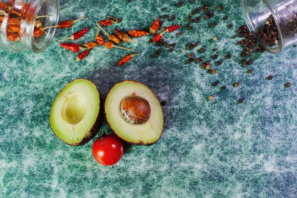 Cut Avocado Half Bone Lies Table Scattered Peppercorns Cherry Tomato — Stock Photo, Image