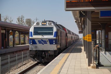 İsrail 'deki bir tren istasyonuna bir tren gelir. Tren, üzerinde kimsenin olmadığı bir platforma yanaşır. Lokomotif vagonları demiryoluna çeker. Demiryolunda yolcu taşımacılığı.