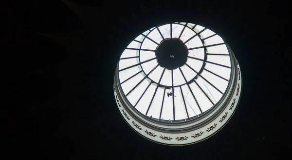 A bird of peace flies in the gap of the church dome. A dove flies against the background of the upper dome of the Church of the Holy Sepulcher. A beautiful image of a flying dove against the background of the glass dome of the church.