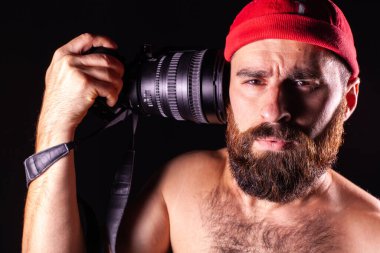 The boy's worried look. The model looks directly into the camera. Guy on a black background with a camera at his temple