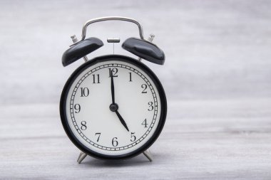 black vintage alarm clock standing on the table with color ,